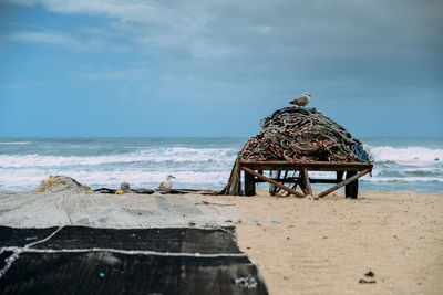 Rear view of lifeguard hut on beach against sky