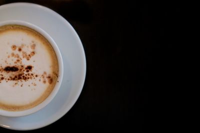 Directly above shot of coffee cup against black background