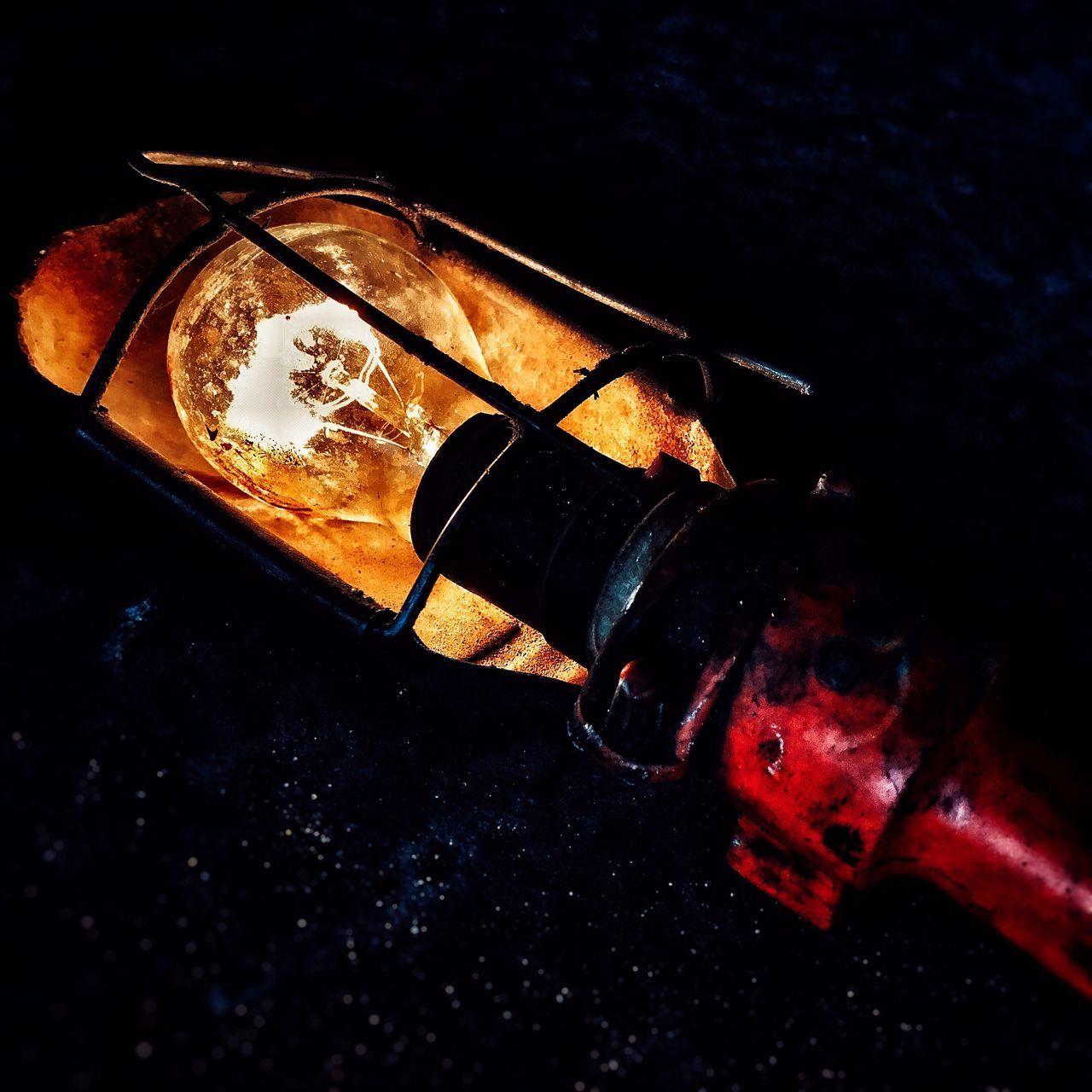 CLOSE-UP OF ILLUMINATED HAND AGAINST BLACK BACKGROUND