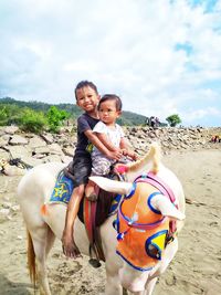 Full length of boy and girl riding on horse