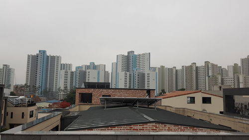 Buildings in city against clear sky