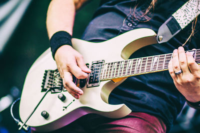 Midsection of man playing guitar