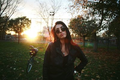 Portrait of young woman in sunglasses standing in park