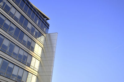 Low angle view of modern building against blue sky