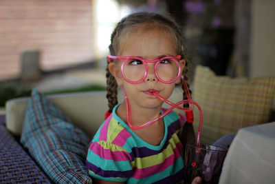 Portrait of young woman wearing sunglasses on table