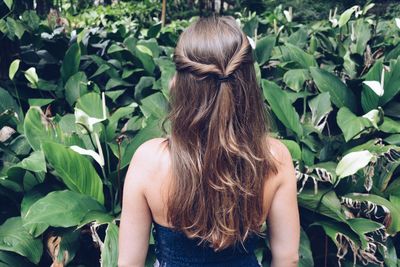 Rear view of woman standing against plants