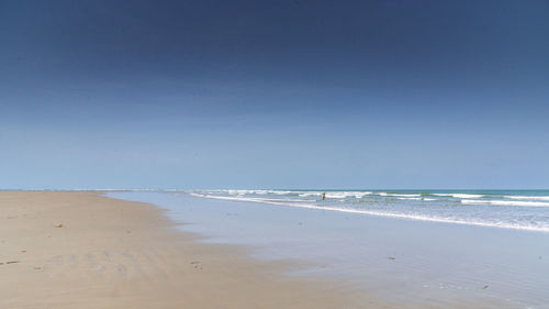 Scenic view of beach against clear blue sky