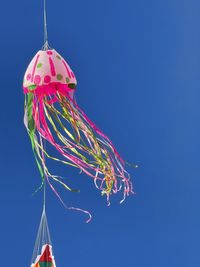 Low angle view of decoration hanging against clear blue sky