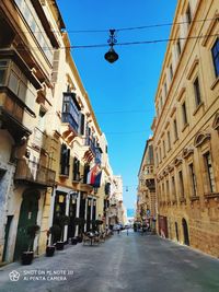 Street amidst buildings against sky in city