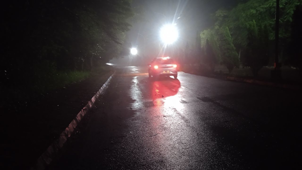 transportation, darkness, mode of transportation, night, light, road, wet, illuminated, rain, motor vehicle, car, headlight, street, land vehicle, city, nature, fog, vehicle, sign, dark, outdoors, the way forward, tree, no people, lighting equipment