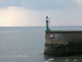 Built structure by sea against sky