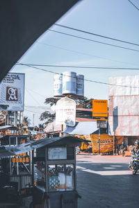 Information sign on street in city against sky