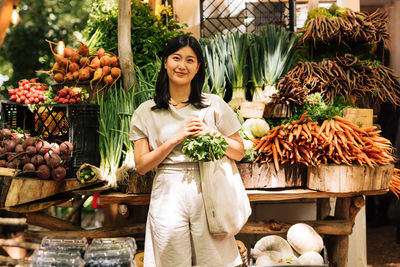 Portrait of woman holding fruits at market