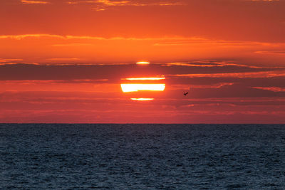 Scenic view of sea against orange sky