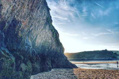 Scenic view of sea by cliff against sky