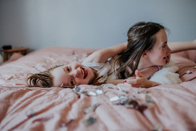 Sisters laying on a bed playing together