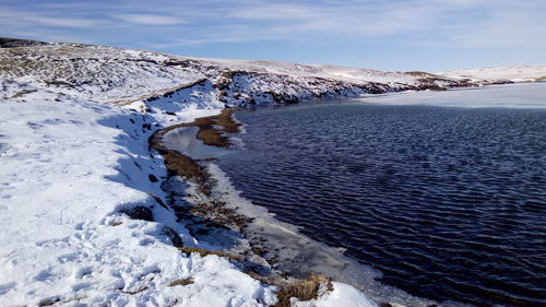 Partly frozen lake up the waterfall in iceland