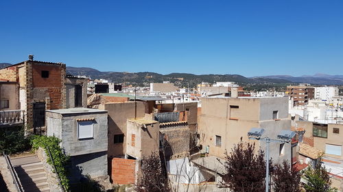 Buildings in city against clear blue sky