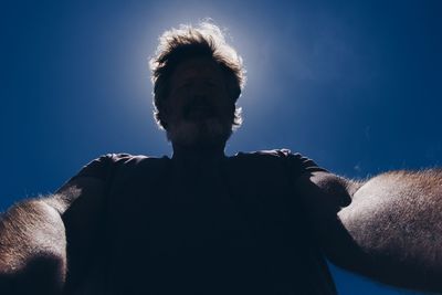 Low angle view of man against blue sky