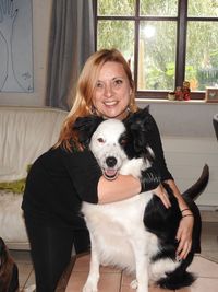 Portrait of smiling woman with dog at home
