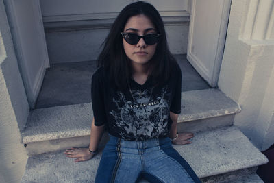 Portrait of beautiful young woman sitting on staircase