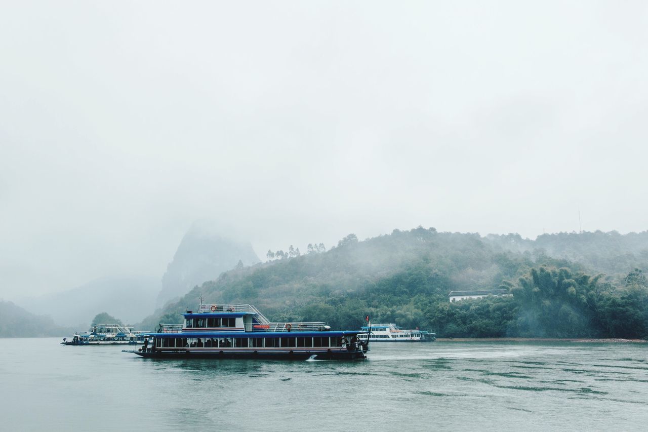 nautical vessel, mode of transport, nature, tranquil scene, fog, passenger craft, travel, beauty in nature, tranquility, tourism, water, environment, travel destinations, scenics, outdoors, boathouse, business finance and industry, mountain, ferry, sky, no people, architecture, day