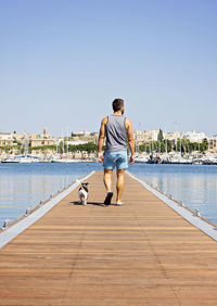 Rear view of man walking on pier