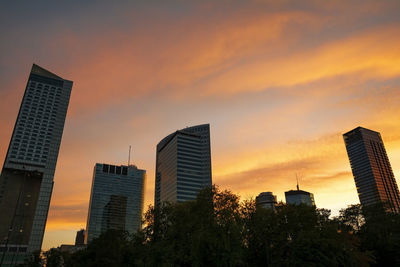 Low angle view of modern buildings against sky during sunset