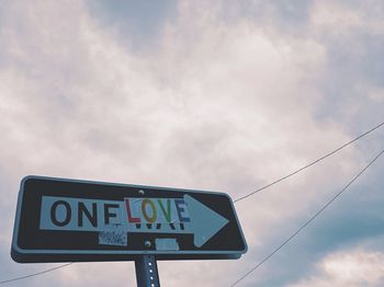 Low angle view of road sign against sky