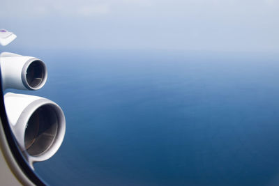 Airplane flying over sea against blue sky