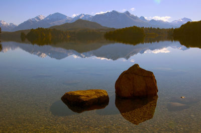 Rocks in lake against sky