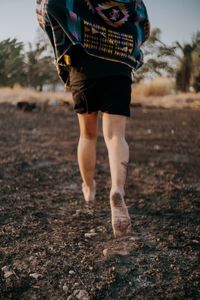 Low section of woman walking on field