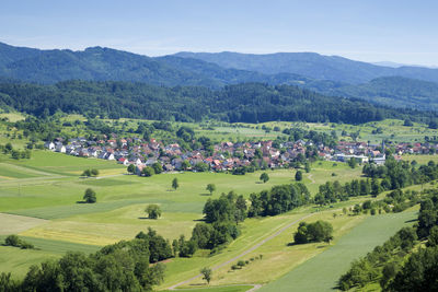 Scenic view of green landscape and mountains against sky