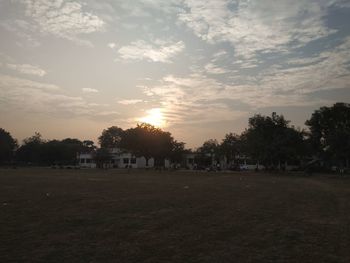 Trees in park against sky during sunset