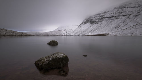 Scenic view of lake and rocks against sky