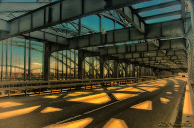 Empty road by building against sky