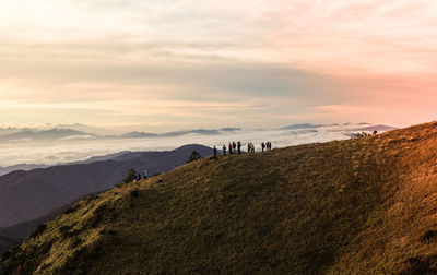 High angle view of people standing on mountain against sky