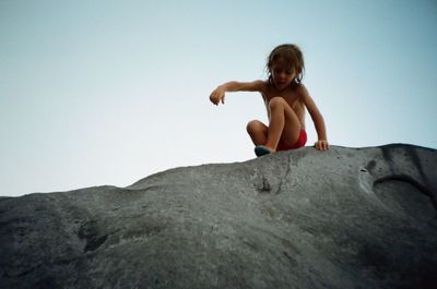 Low angle view of woman standing on rock formation