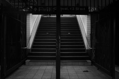 Interior shot of the 42nd street subway station platform staircase. a rat runs passed the stairs