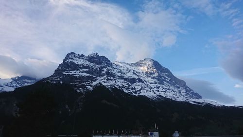 Low angle view of snowcapped mountains against sky