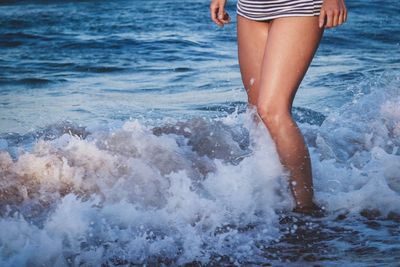 Low section of woman standing on beach