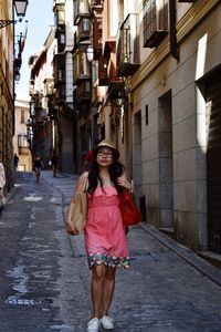 Portrait of smiling young woman standing in city