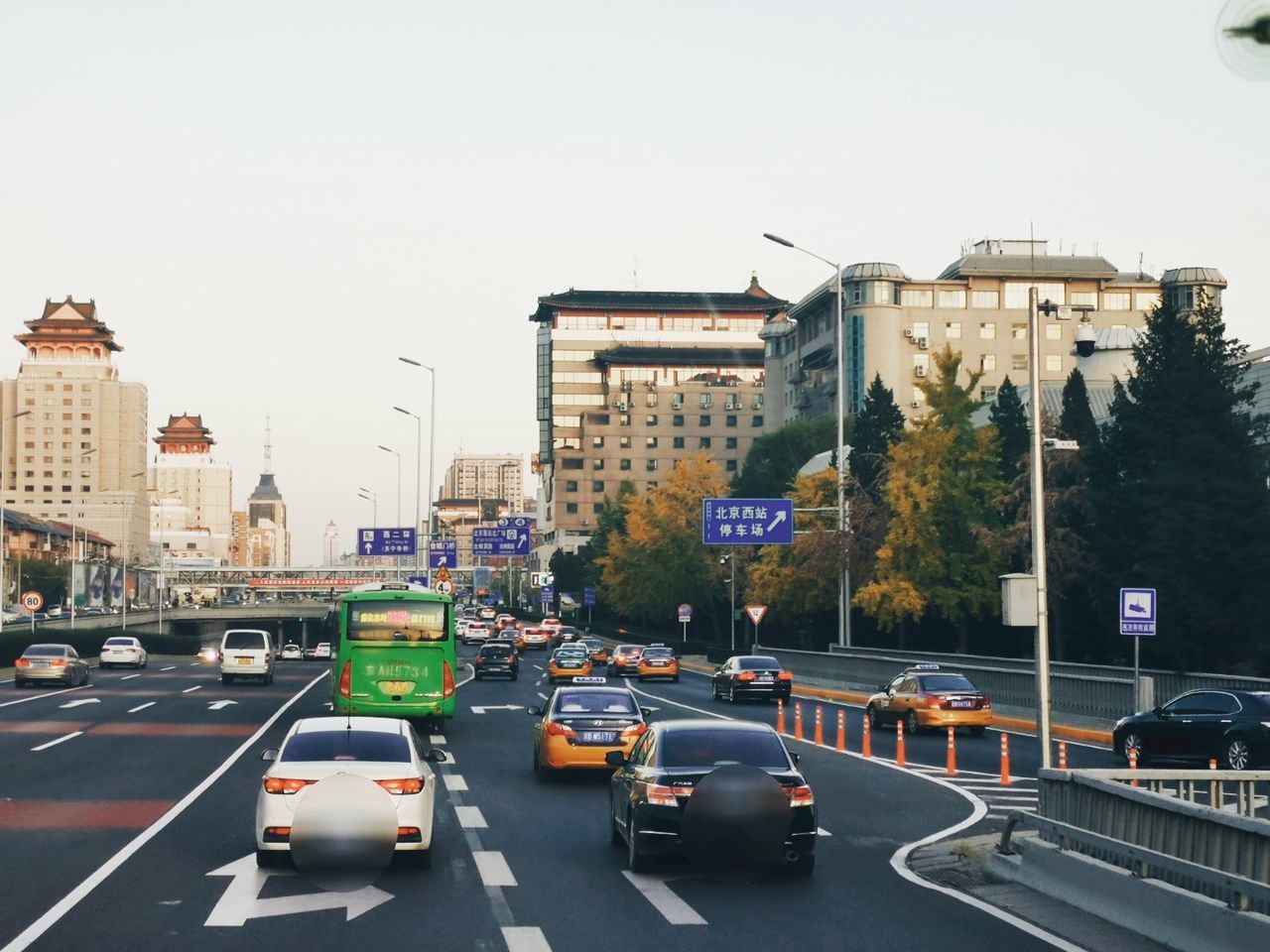 car, transportation, mode of transportation, motor vehicle, road, city, land vehicle, building exterior, architecture, street, built structure, sky, sign, symbol, traffic, road marking, marking, nature, city life, motion, no people, outdoors