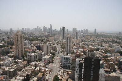 Aerial view of buildings in city against clear sky