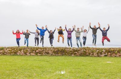 People standing on grassy field against sky