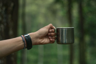 Close-up of hand holding drink against blurred background