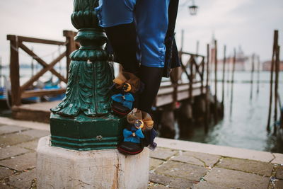 Man standing on footpath by railing