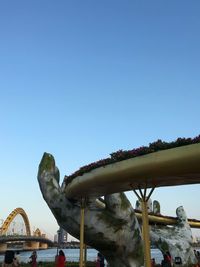 Bridge in amusement park against clear blue sky