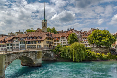 Arch bridge over river against buildings