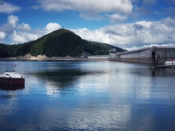 Scenic view of river by mountain against sky